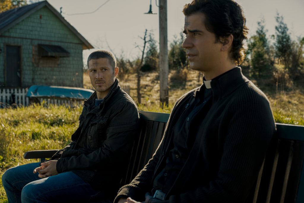 MIDNIGHT MASS (L to R) ZACH GILFORD as RILEY FLYNN and HAMISH LINKLATER as FATHER PAUL in episode 102 of MIDNIGHT MASS Cr. EIKE SCHROTER/NETFLIX © 2021